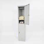 A light grey two-compartment locker with the top door open, with some folded polo tee and a pair of sneakers on the under compartment