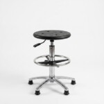 The single, textured black seat is fully lowered, near the chrome foot ring, with the pneumatic column fully retracted.