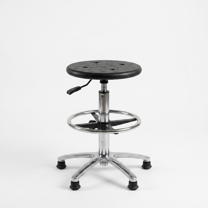 The single, textured black seat is fully lowered, near the chrome foot ring, with the pneumatic column fully retracted.