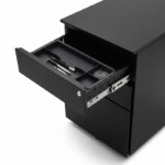 Close-up of an iSimply executive black steel mobile pedestal with the top drawer open, revealing a removable black stationery tray with compartments for office supplies.