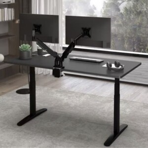 Flexispot heavy-duty dual monitor arm in matte black supporting two large screens on an ergonomic standing desk.